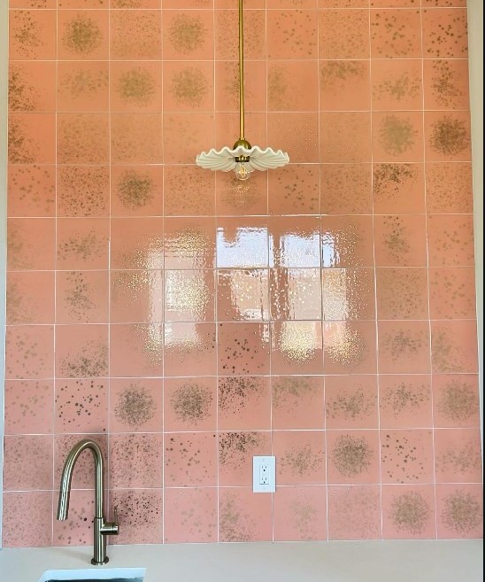 Wet room in blush speckled terrazzo tile with a brass pendant