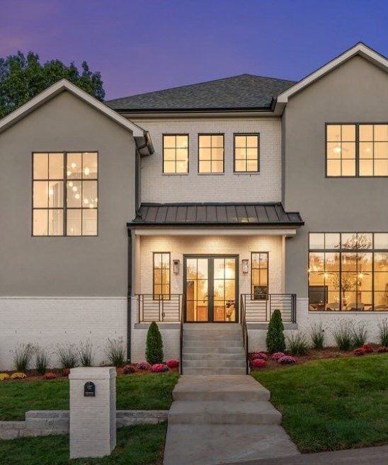 New-construction exterior at dusk, every window lit