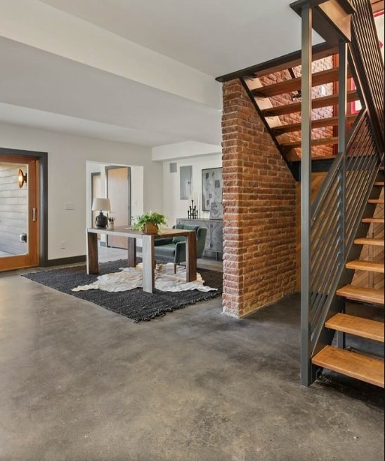 Open stair in blackened steel against an exposed brick wall